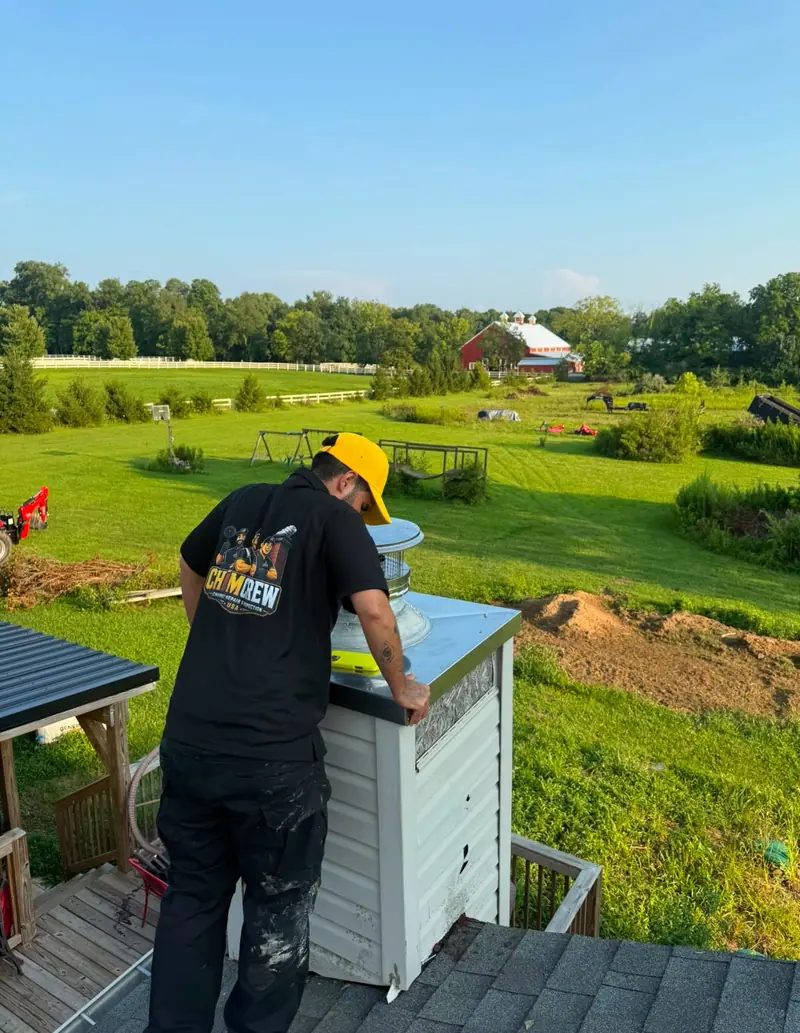 Chimcrew - Chimney Sweep & Repair tech fitting a new chase cover and cap on a country home